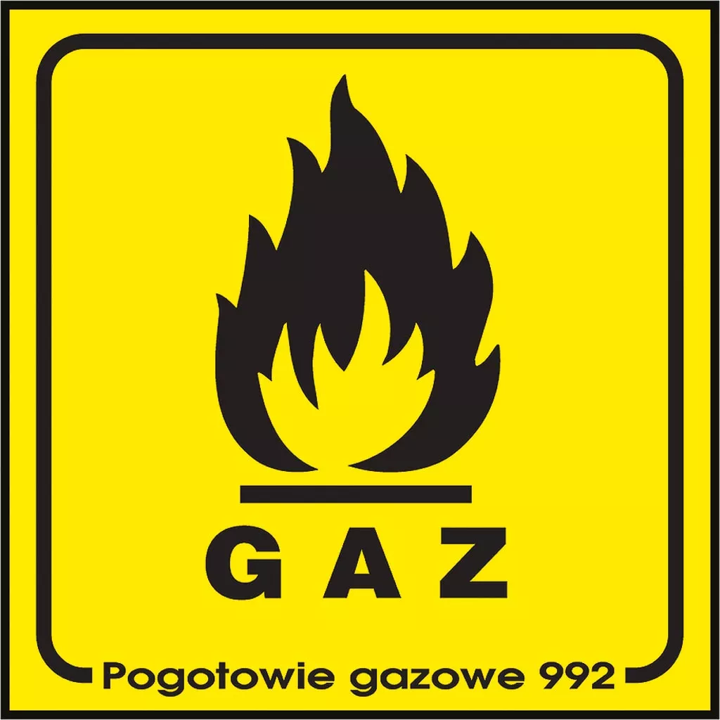 Znak bezpieczeństwa o żółtym tle z czarną grafiką płomienia i napisem „GAZ” w dolnej części. Pod spodem dodatkowy napis „Pogotowie gazowe 992”.