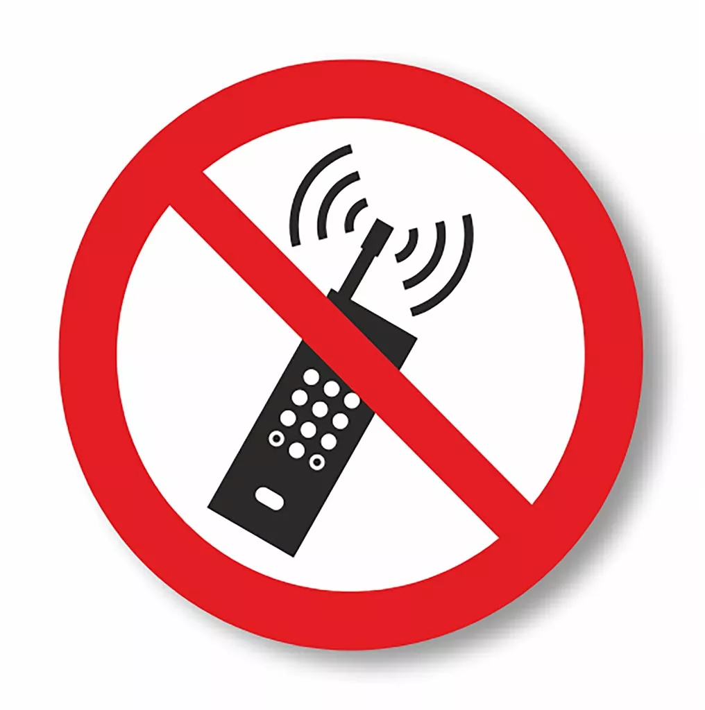 Znak podłogowy przedstawia zakaz używania telefonów komórkowych. Symbol telefonu komórkowego przekreślony jest czerwonym kolistym znakiem zakazu.