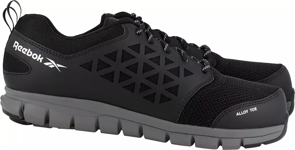Czarne półbuty bezpieczne Reebok, model IB1031S1P EXCEL LIGHT. Posiadają wzór w formie przekątnych linii i siateczkową strukturę, podeszwa z grubym bieżnikiem, logo na boku.