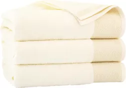 Ręcznik Elipse w kolorze białym, wykonany z tkaniny o strukturze frotte, zdobiony delikatnym reliefowym wzorem. Produkt jest składany w stos kilku sztuk.
